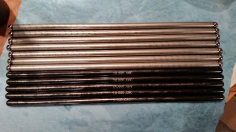 1981 Ford Bronco - A set of engine pushrods are laid out on a blue cloth, some marked with measurements.