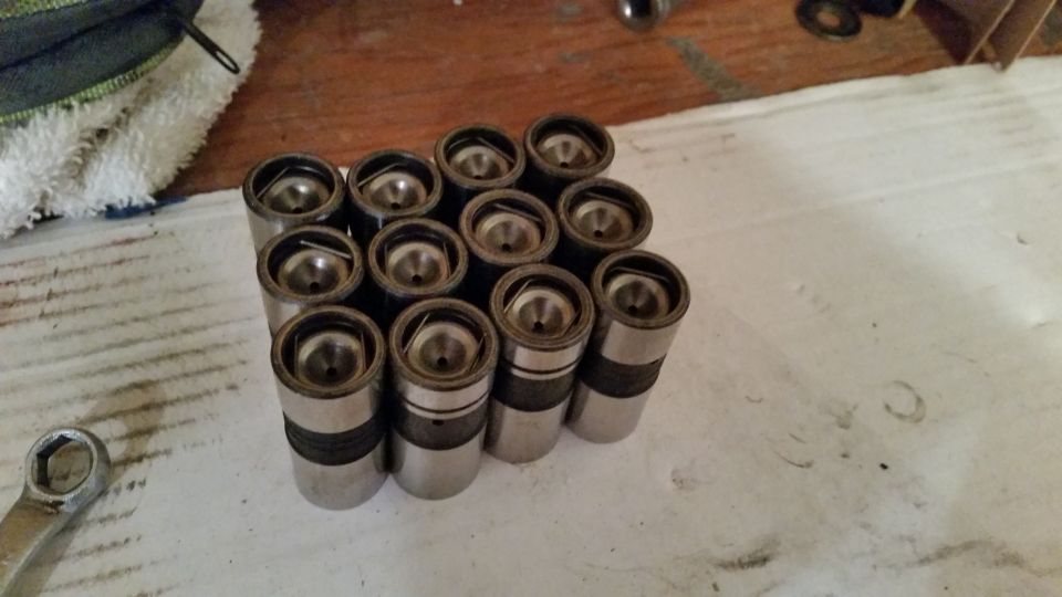 Set of engine lifters on a workbench with a wrench