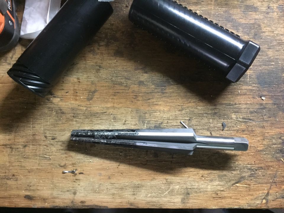 Reamer tool with black handles on a wooden workbench