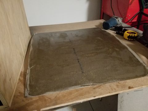 1994 Ford Bronco - A part sits on a workbench with tools nearby, possibly for installation or repair.