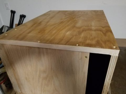 1994 Ford Bronco - A wooden box with a natural wood finish is shown, with a dark opening on the side.