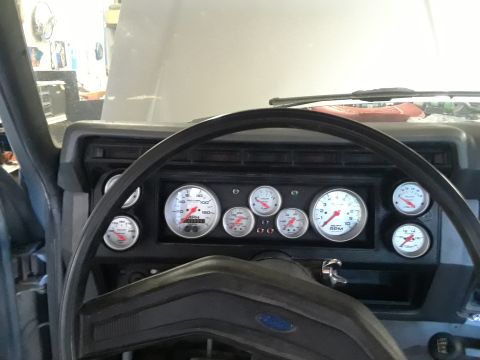 1985 Ford Bronco - Aftermarket gauge cluster installed in a vehicle's dashboard.