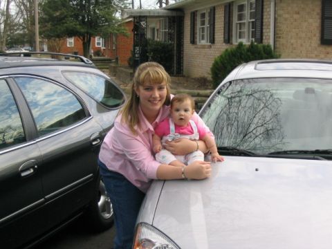 2004 Ford Taurus - A woman and a baby pose with two vehicles in a residential driveway.