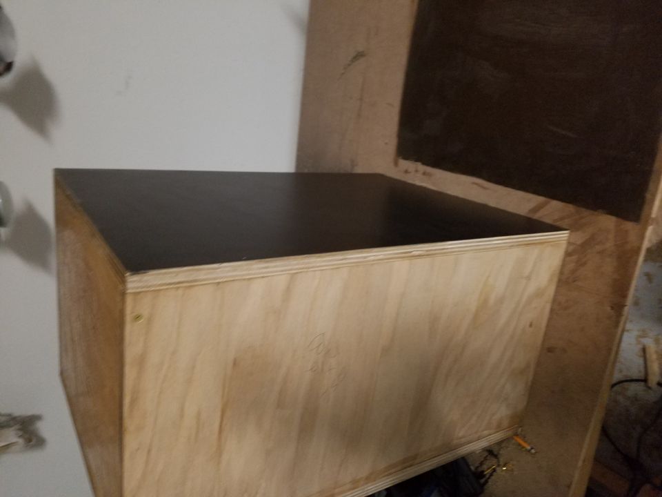 Photo of a plywood enclosure with a black-laminated top