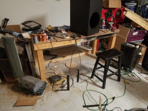 1994 Ford Bronco - Photograph of a garage workshop with a speaker enclosure on the bench, not a technical document.