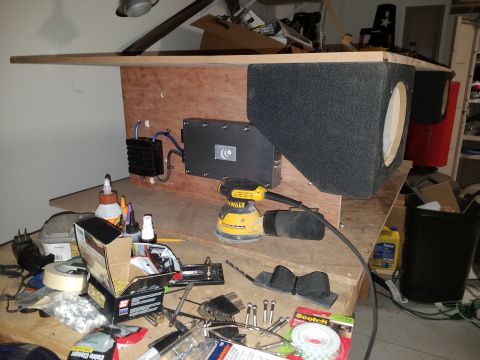 1994 Ford Bronco - Photo of a subwoofer enclosure build with mounted amplifier and tools on a bench, not a technical document.