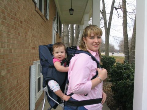 2004 Ford Taurus - A woman smiles while carrying a baby in a backpack carrier on a porch.