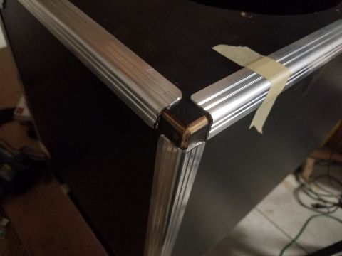 1994 Ford Bronco - Aluminum trim is attached to the corner of a black speaker cabinet with tape.