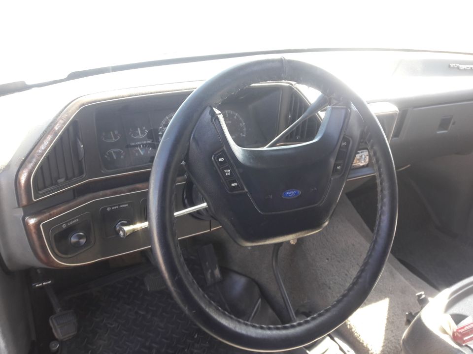 Interior of a 1990 Ford Bronco, showing steering wheel, dashboard, and gauges.