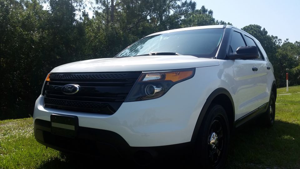 White 2013 Ford Explorer SUV, front quarter view, parked outdoors.