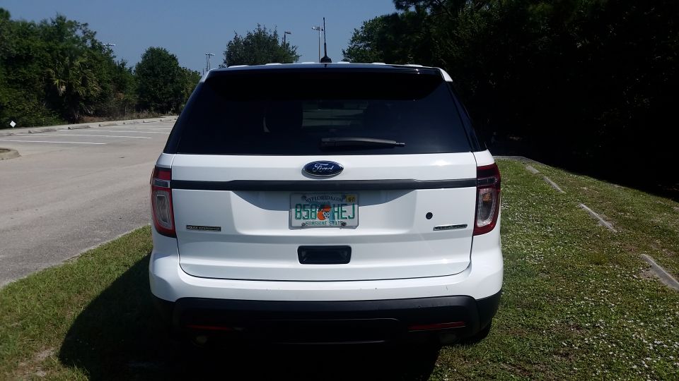 Rear view of a white 2013 Ford Explorer with Florida license plate B58 HEJ.