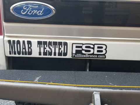1995 Ford Bronco - A close-up view of the rear of a Ford Bronco shows two stickers on the tailgate. The stickers read "MOAB TESTED" and "FSB FullSizeBronco.co…