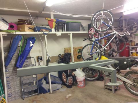 1988 Ford Bronco - A gray metal frame is positioned in front of a dirt bike in a garage setting. The frame appears to be a custom-built part, possibly for a v…