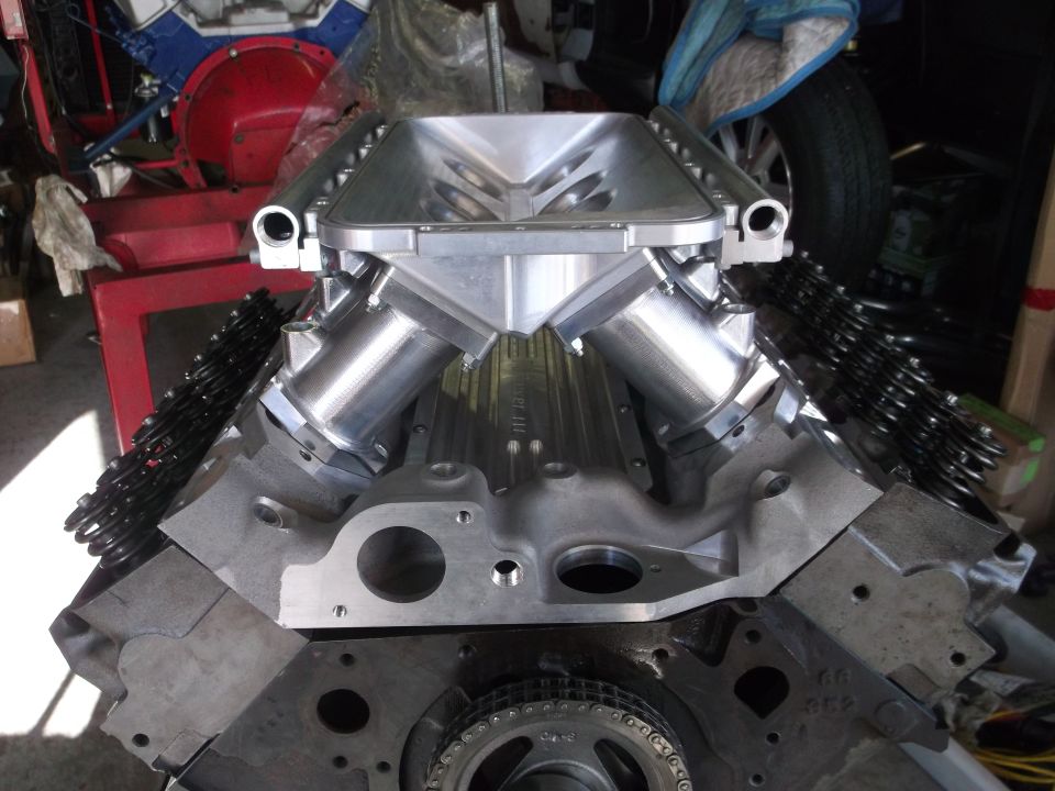 Close-up of a V8 engine block with polished aluminum intake manifold and valve springs.