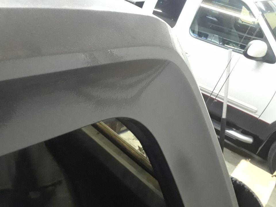 Close-up of a gray fender flare on a vehicle.