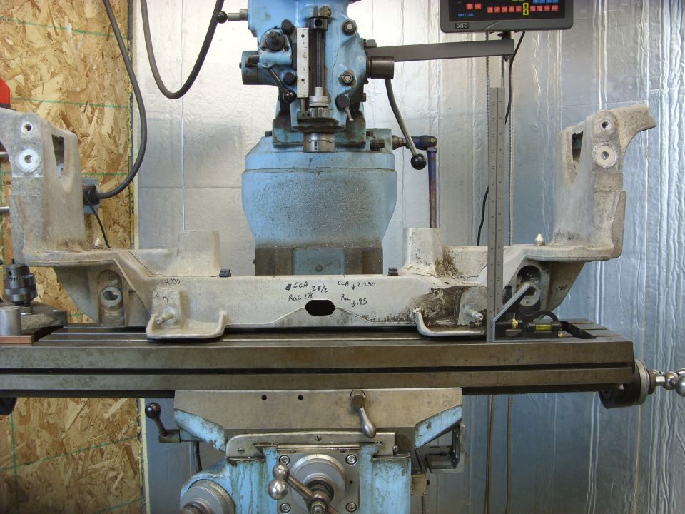 Metal part on milling machine table with handwritten measurements