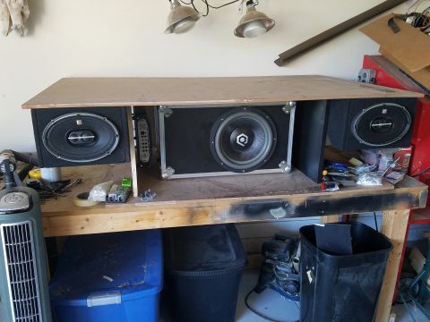 1994 Ford Bronco - A custom-built speaker enclosure, a large subwoofer and two smaller speakers, is displayed on a workbench.