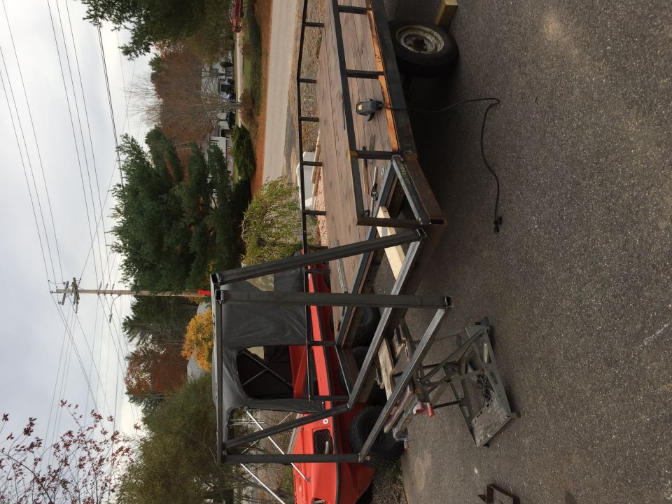 Trailer frame over red truck cab, parked on asphalt