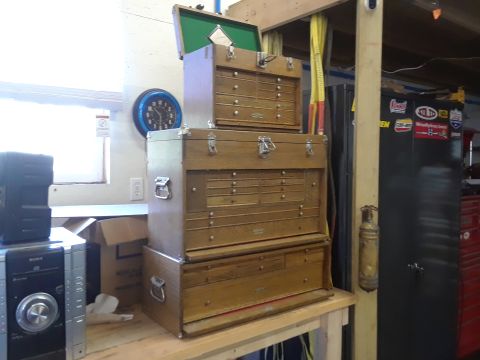 1994 Ford Bronco - Wooden tool chests are stacked on a workbench next to a stereo system and a wall clock.