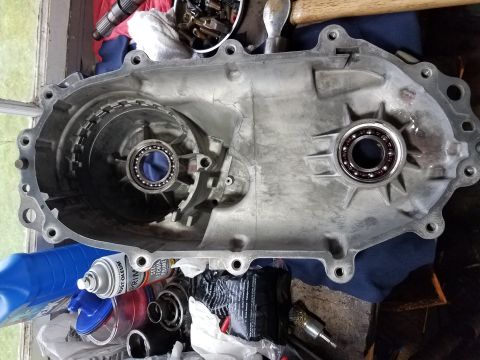 1996 Ford Bronco - A disassembled transmission housing is shown with its internal components and surrounding tools and supplies.