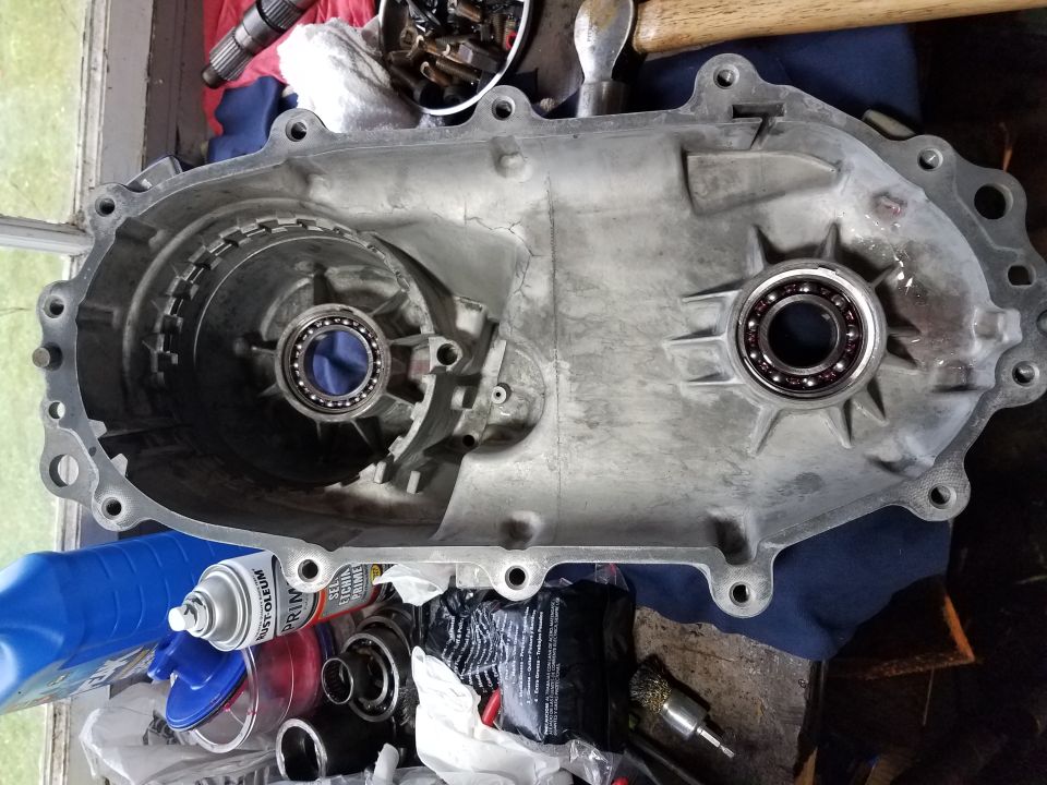 Transmission housing with internal gears and bearings, next to spray paint and tools