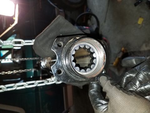 1996 Ford Bronco - Close-up of a splined shaft hub with roller bearings, held by gloved hands during a repair.
