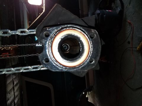 1996 Ford Bronco - Close-up of an exhaust pipe flange, with a chain visible in the background.