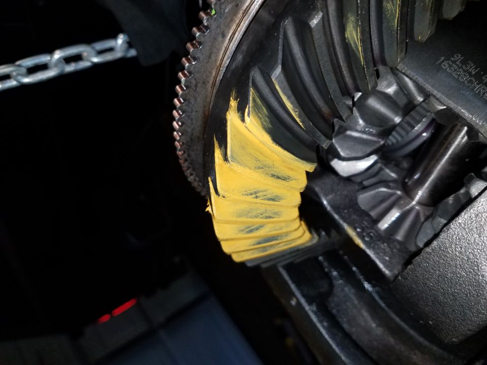 Differential ring gear with yellow marking compound and a metal chain.