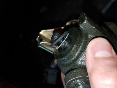 1996 Ford Bronco - A close-up shot shows a person's thumb holding a dark-colored metal automotive part. The part has a threaded opening at the bottom and a ci…