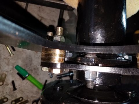 1996 Ford Bronco - A close-up view shows a stack of metal plates and bolts, possibly part of a suspension or mounting system, with a black cylindrical object…