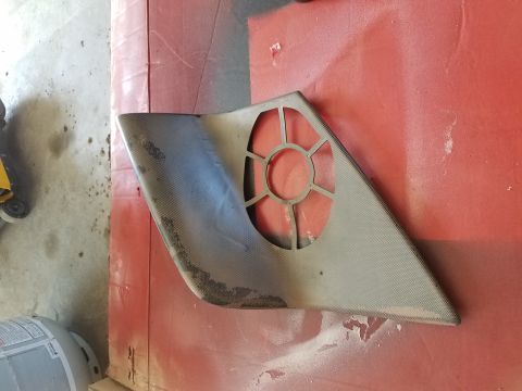 1996 Ford Bronco - A custom triangular-shaped carbon fiber part with a circular cutout is shown resting on a red surface. The part appears to be a speaker gri…