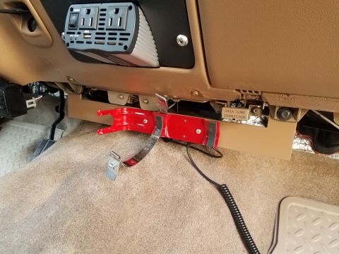 1996 Ford Bronco - This is an interior shot of a vehicle's dashboard area, showing a power inverter mounted above a red fire extinguisher mount. A coiled blac…