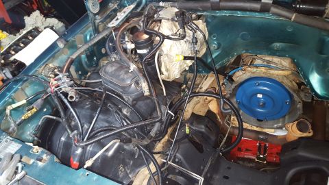 1996 Ford Bronco - The engine bay of a 1996 Ford Bronco is shown with the transmission and torque converter visible. Various hoses, wires, and engine componen…