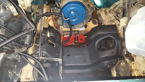 1996 Ford Bronco - This is an undercarriage view of a vehicle's engine bay, showing the transmission, exhaust manifolds, and various hoses and wiring. A red h…