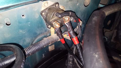1996 Ford Bronco - A close-up view shows a Ford starter solenoid mounted to a teal-colored engine bay. Red and black heat shrink tubing covers the wires conne…