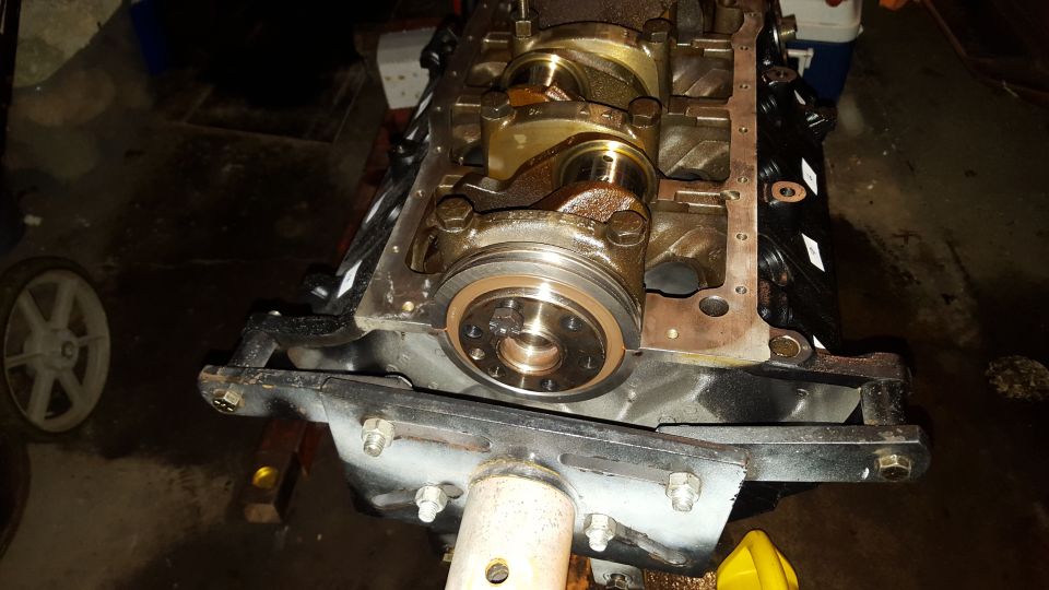 Engine crankshaft and main bearing caps with bronze bearings and a silver seal.