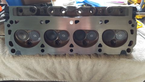 1996 Ford Bronco - A close-up, overhead view of a cleaned engine cylinder head with four intake and exhaust valves visible. The metal surface is shiny and cle…