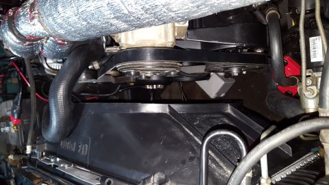 1996 Ford Bronco - A close-up view of the engine bay of a 1996 Ford Bronco shows the serpentine belt system, fan shroud, and various hoses. The engine compone…
