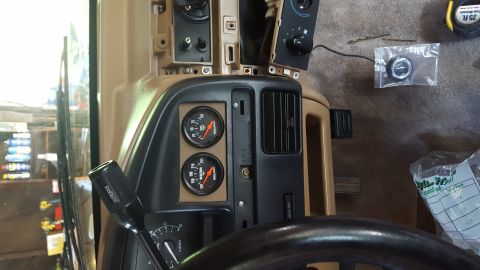 1996 Ford Bronco - The interior of a vehicle shows a dashboard with two gauges, an air vent, and part of the steering wheel. A black gear shifter with "OVERDR…