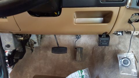 1996 Ford Bronco - The interior of a vehicle shows the driver's side footwell with brake and accelerator pedals visible. A control module with "4x4" and "LOW…