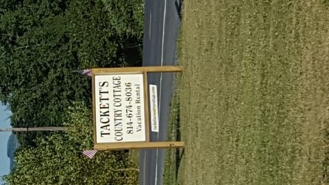 1996 Ford Bronco - A sign for Tackett's Country Cottage Vacation Rental is visible next to a road. The sign includes a phone number and a website address.