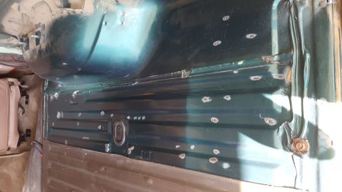 1996 Ford Bronco - The interior of a dark green vehicle shows the floor pan with multiple small circular indentations, likely from spot welding. A portion of…