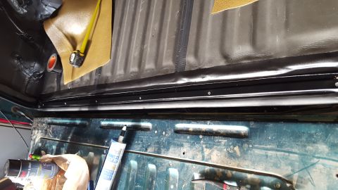 1996 Ford Bronco - The interior of a vehicle bed shows a black rubber seal installed along the top edge of the tailgate opening, with various automotive produ…