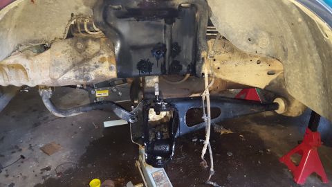 1996 Ford Bronco - A vehicle's front suspension components are shown, with the lower control arm and steering knuckle painted black. The scene appears to be a…