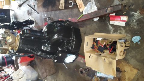 1996 Ford Bronco - A freshly painted black differential housing is shown in a workshop setting. A cardboard box containing parts, possibly for the differentia…