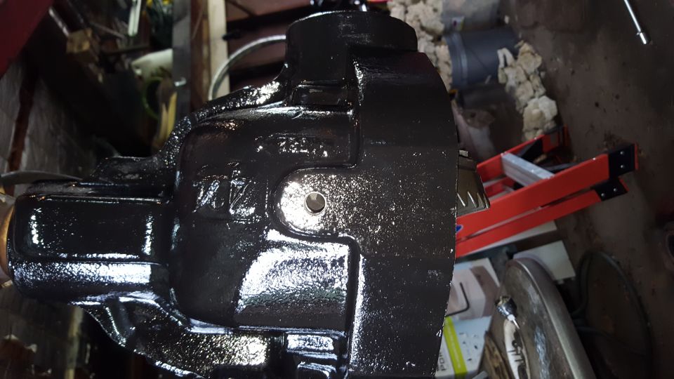 Black cast iron vehicle part with visible lettering and a circular opening.