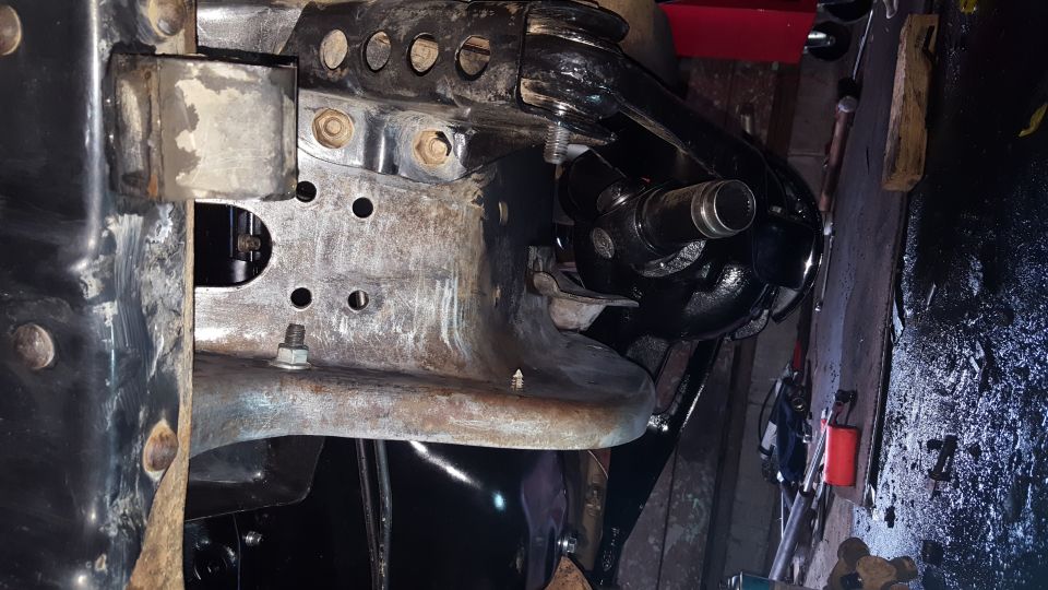 Undercarriage of a vehicle showing suspension and frame components.