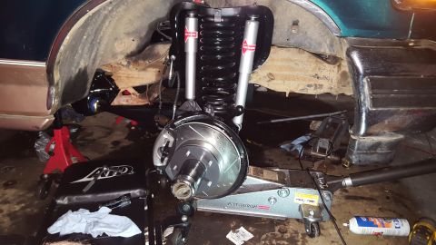 1996 Ford Bronco - A front suspension and brake assembly is shown, with new shocks, springs, and a slotted rotor installed. The vehicle appears to be on jack…