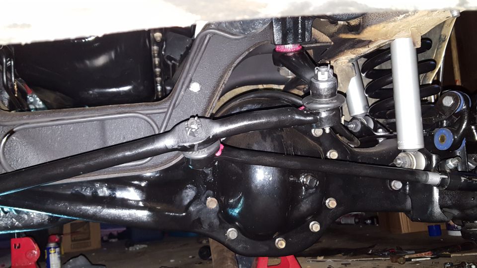 Underside view of a vehicle's rear axle and suspension, showing black painted components.