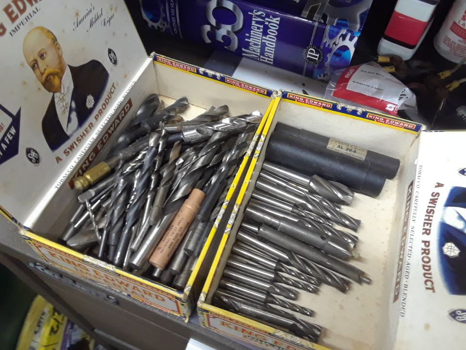Two vintage cigar boxes filled with drill bits and reamers.